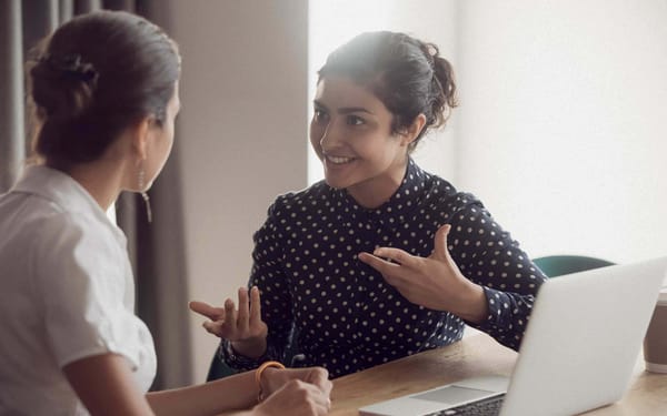 Two women speaking in a clinical setting.