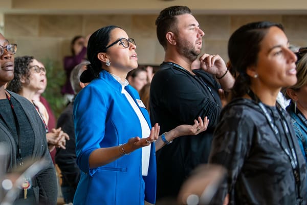 A group of faculty and students sing and take part in worship.