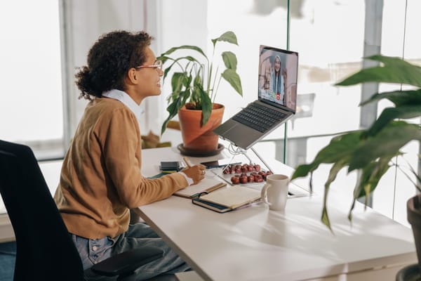 Two women speak to each other through a video call on a computer.