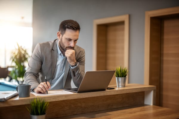 Businessman working on a laptop at a wooden desk